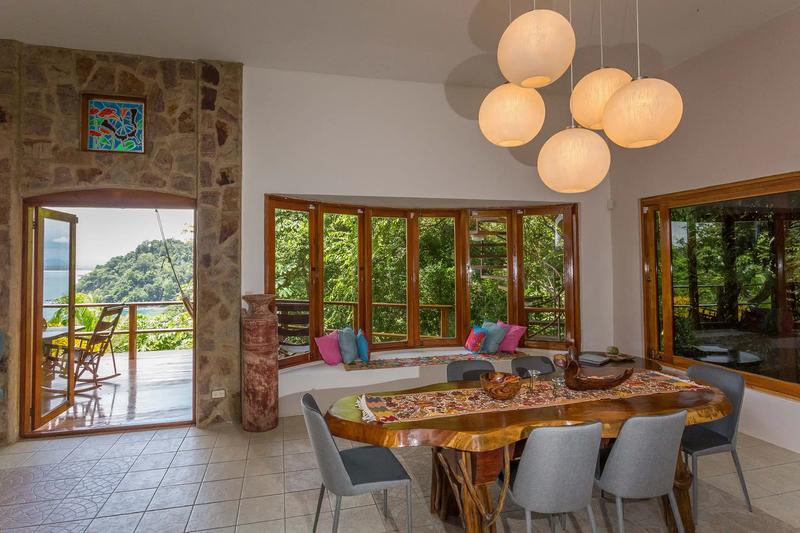 Dining room at Casa Pura Paz with live edge table and stone archway to the deck