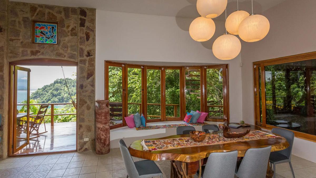 Dining room at Casa Pura Paz with live edge table and stone archway to the deck