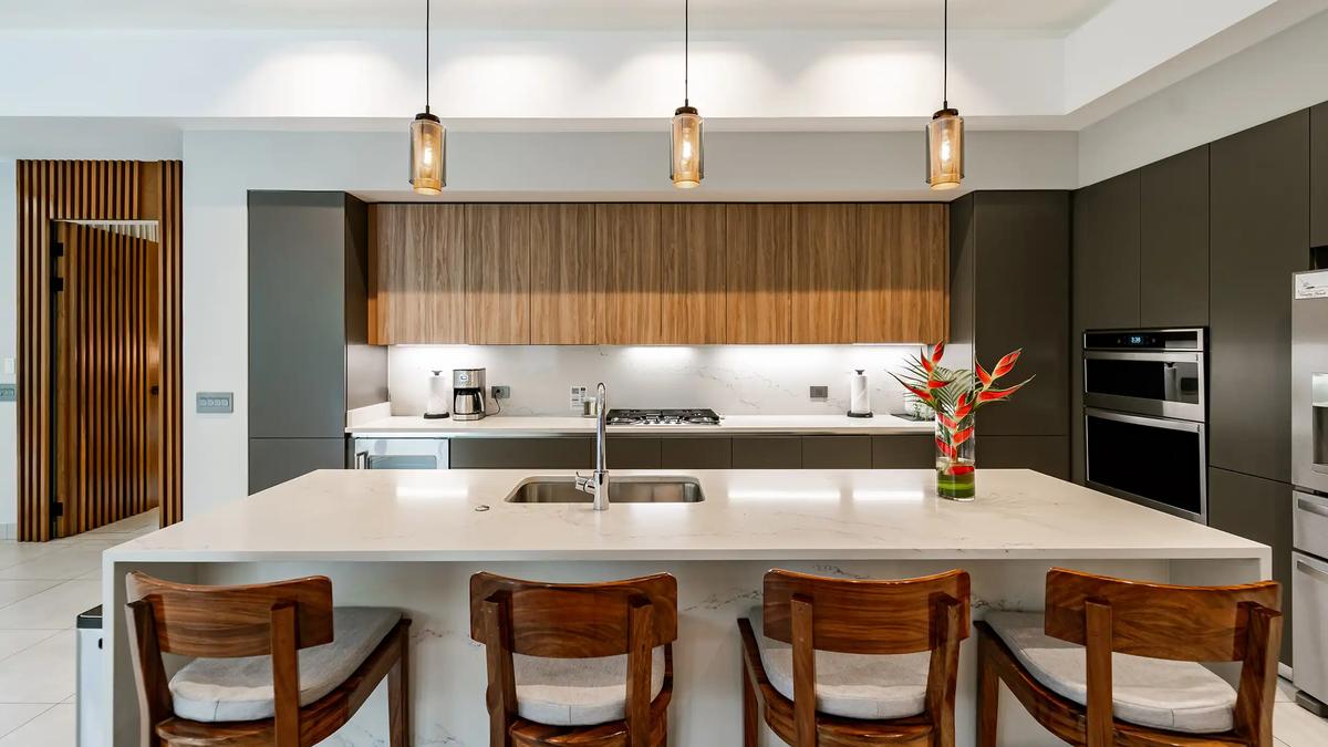 Quartz island kitchen at Casa Blue Marlin with wooden bar stools and pendants