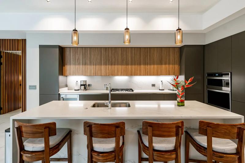 Quartz island kitchen at Casa Blue Marlin with wooden bar stools and pendants