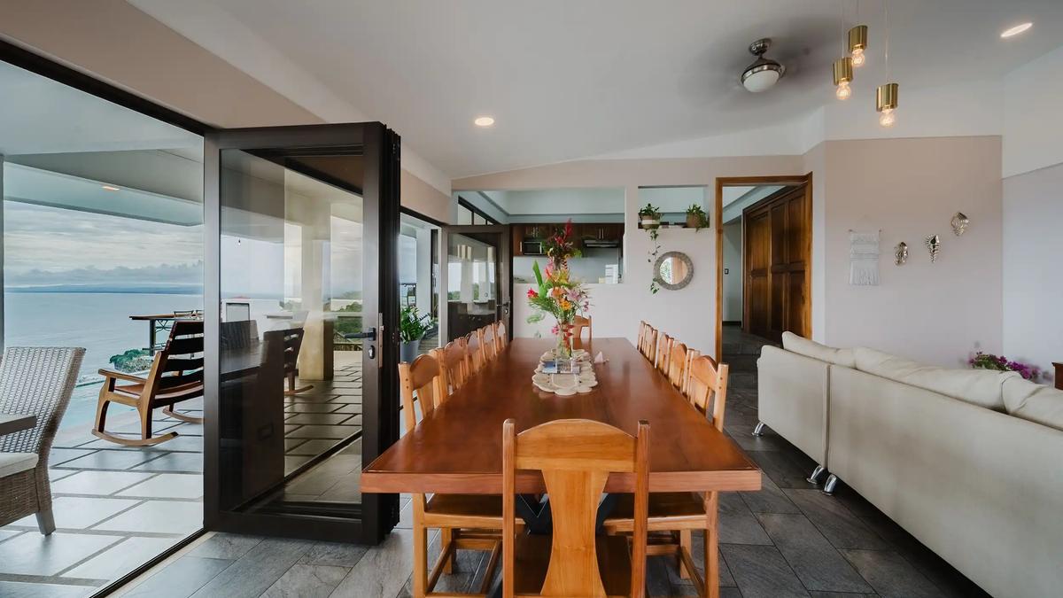Dining room at Casa Grande Vista opening through folding glass doors to the terrace