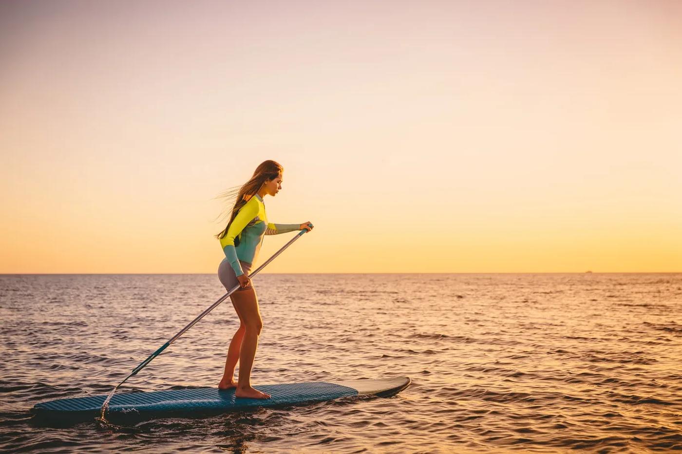 Paddleboarder on the ocean at sunset