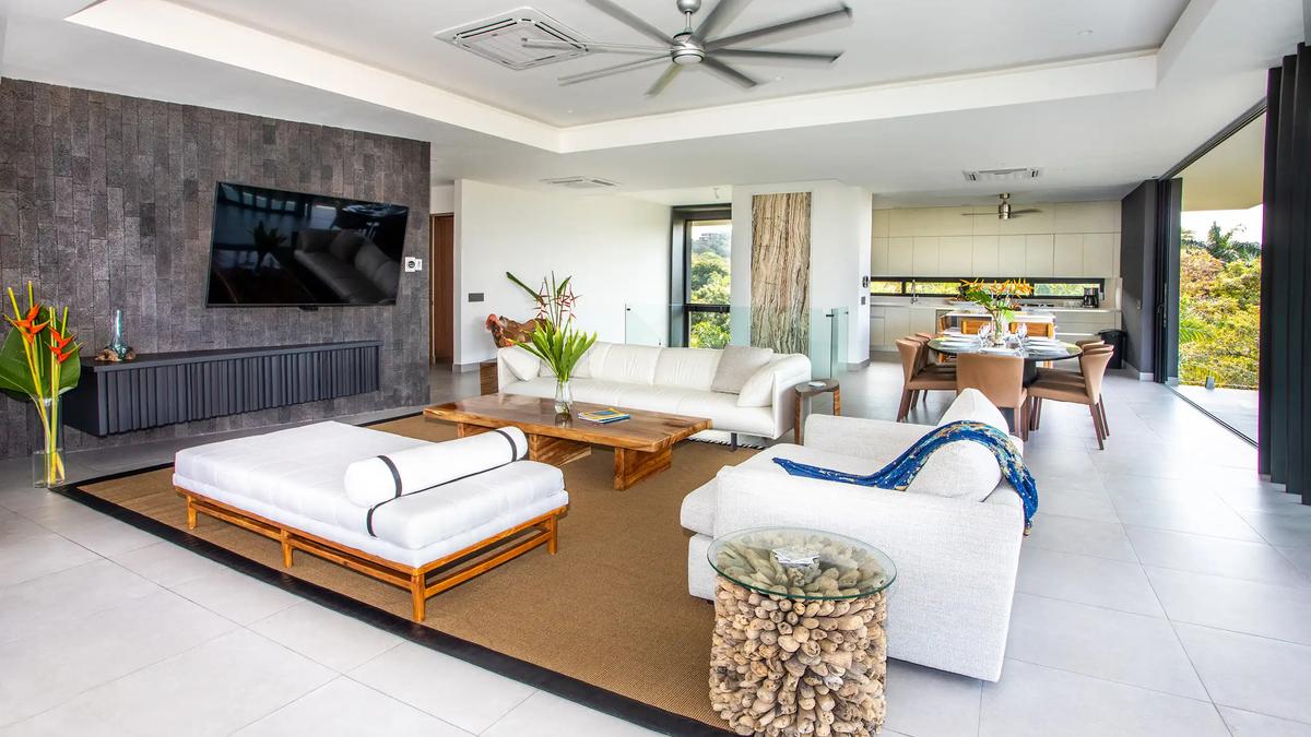 Living and dining space at Casa Nueva Vida with daybed, white sofas, and rainforest light