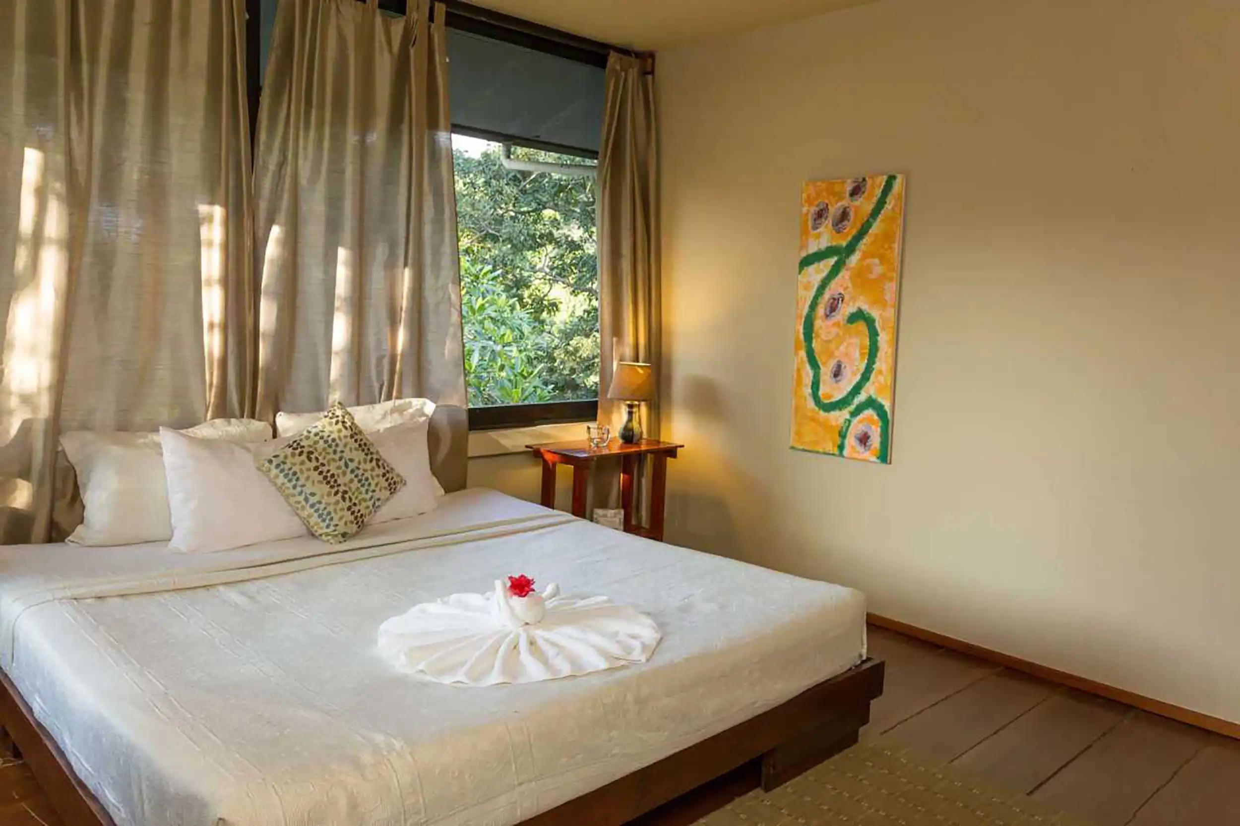 Casa Luz bedroom with folded towel fan on the bed and jungle window