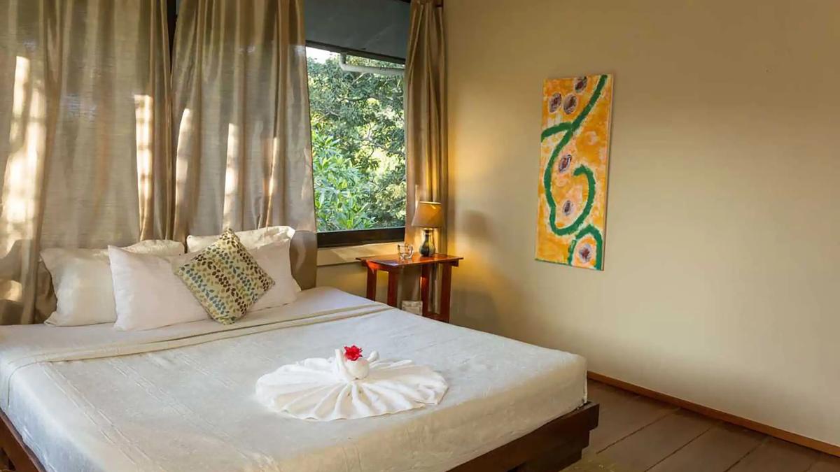 Casa Luz bedroom with folded towel fan on the bed and jungle window
