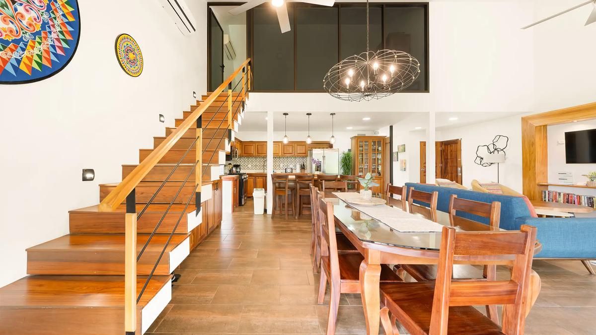Open plan dining area and staircase inside Casa Vista Verde with oxcart wheel art