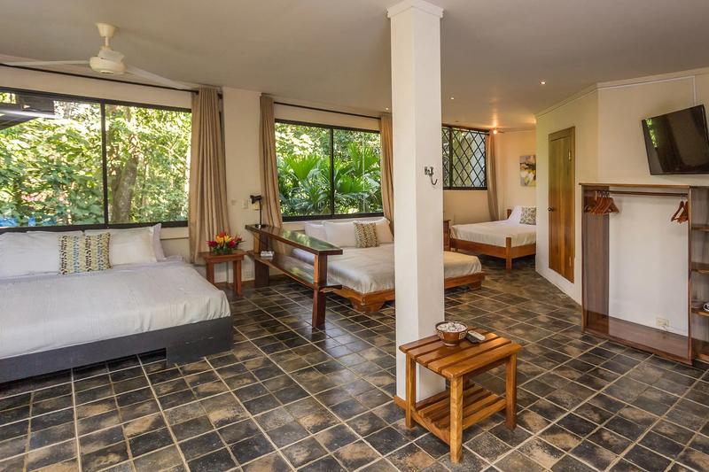 Open plan Casa Luz bedroom with three beds, TV and hanging rack
