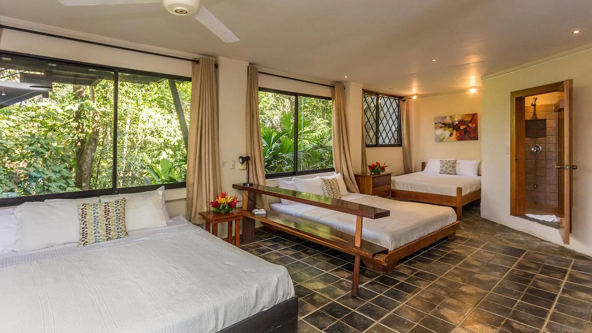 Spacious Casa Luz room with three beds and jungle views through corner windows