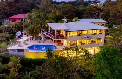Evening aerial view of Casa Mariposa showing pool deck, spiral staircase, and shade sails