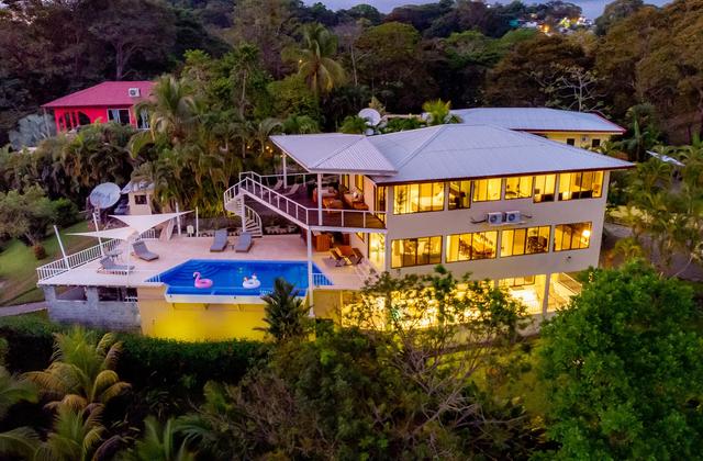 Evening aerial view of Casa Mariposa showing pool deck, spiral staircase, and shade sails