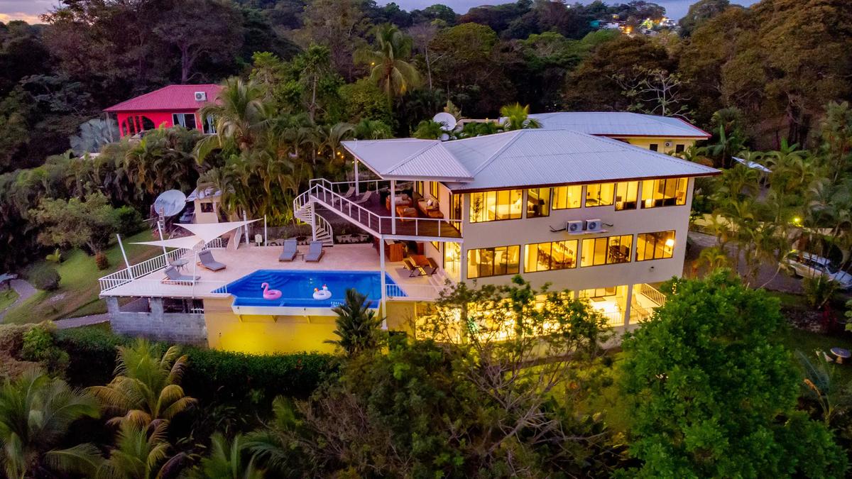 Evening aerial view of Casa Mariposa showing pool deck, spiral staircase, and shade sails