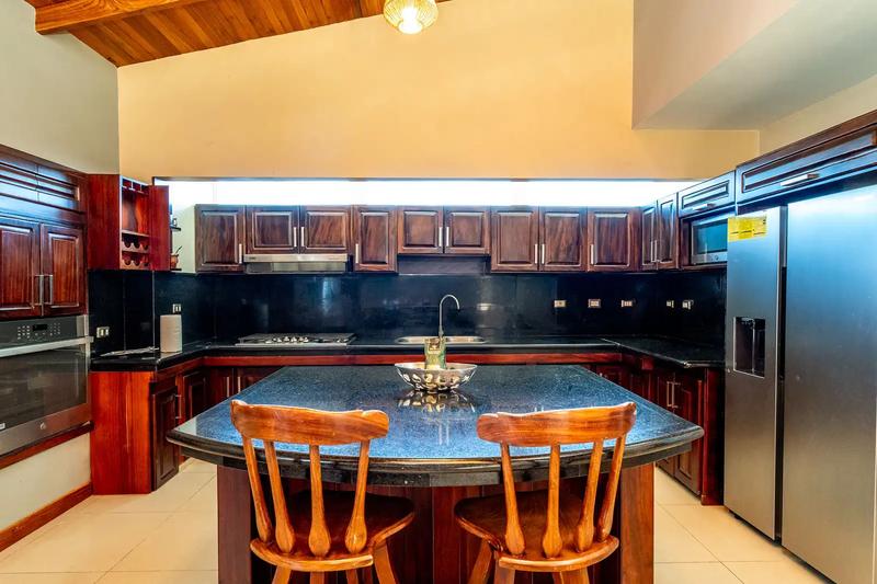 Kitchen with hardwood cabinets, granite island, and stainless appliances at Casa Alta Vista