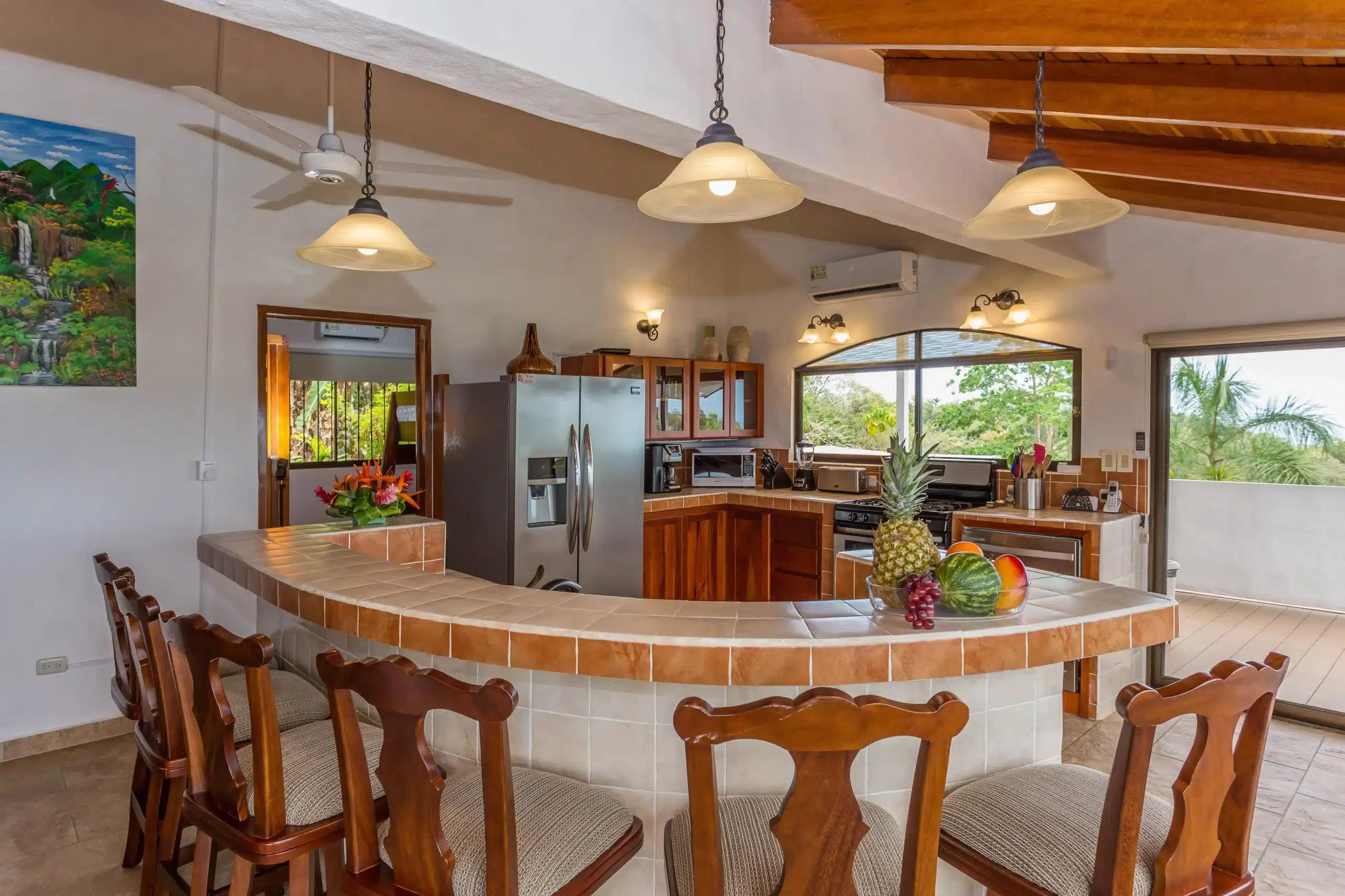 Curved tile breakfast bar at Casa Moreno with fresh fruit and stainless kitchen