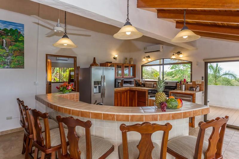 Curved tile breakfast bar at Casa Moreno with fresh fruit and stainless kitchen