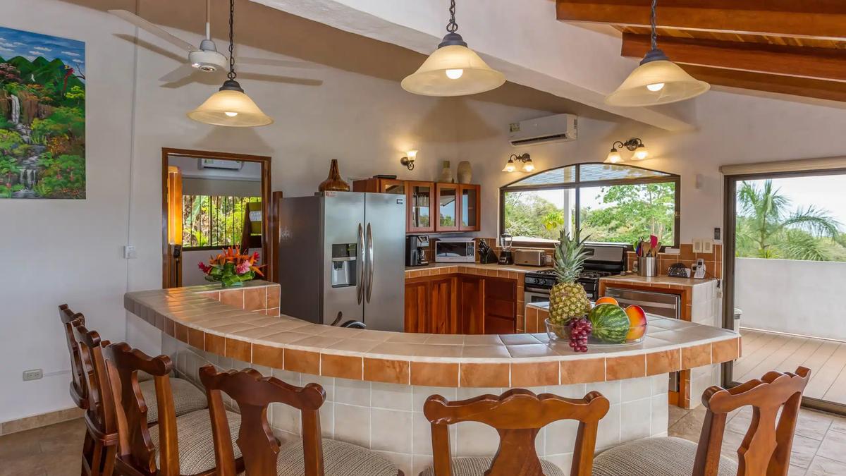 Curved tile breakfast bar at Casa Moreno with fresh fruit and stainless kitchen