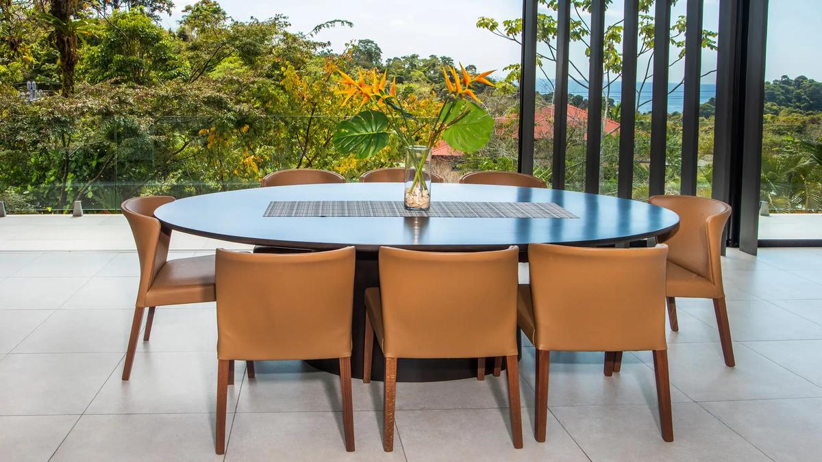 Heliconia centerpiece on the oval dining table at Casa Nueva Vida framed by jungle