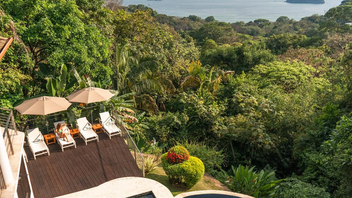 Aerial view of Casa Anjali's sun deck above rainforest running to the sea