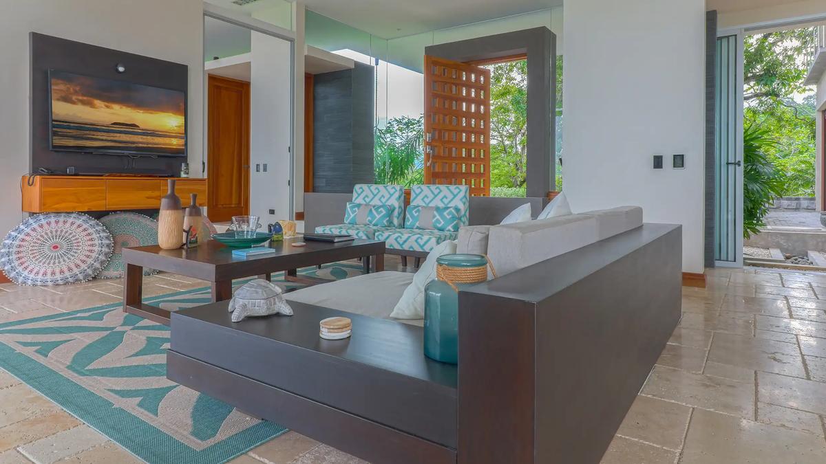 Casa Contee living room with sectional sofa, TV, and turquoise accents