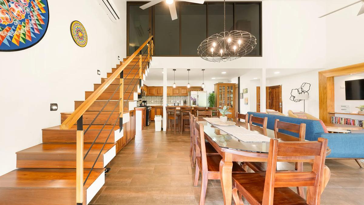 Casa Vista Verde great room with wood staircase, long dining table, and open kitchen