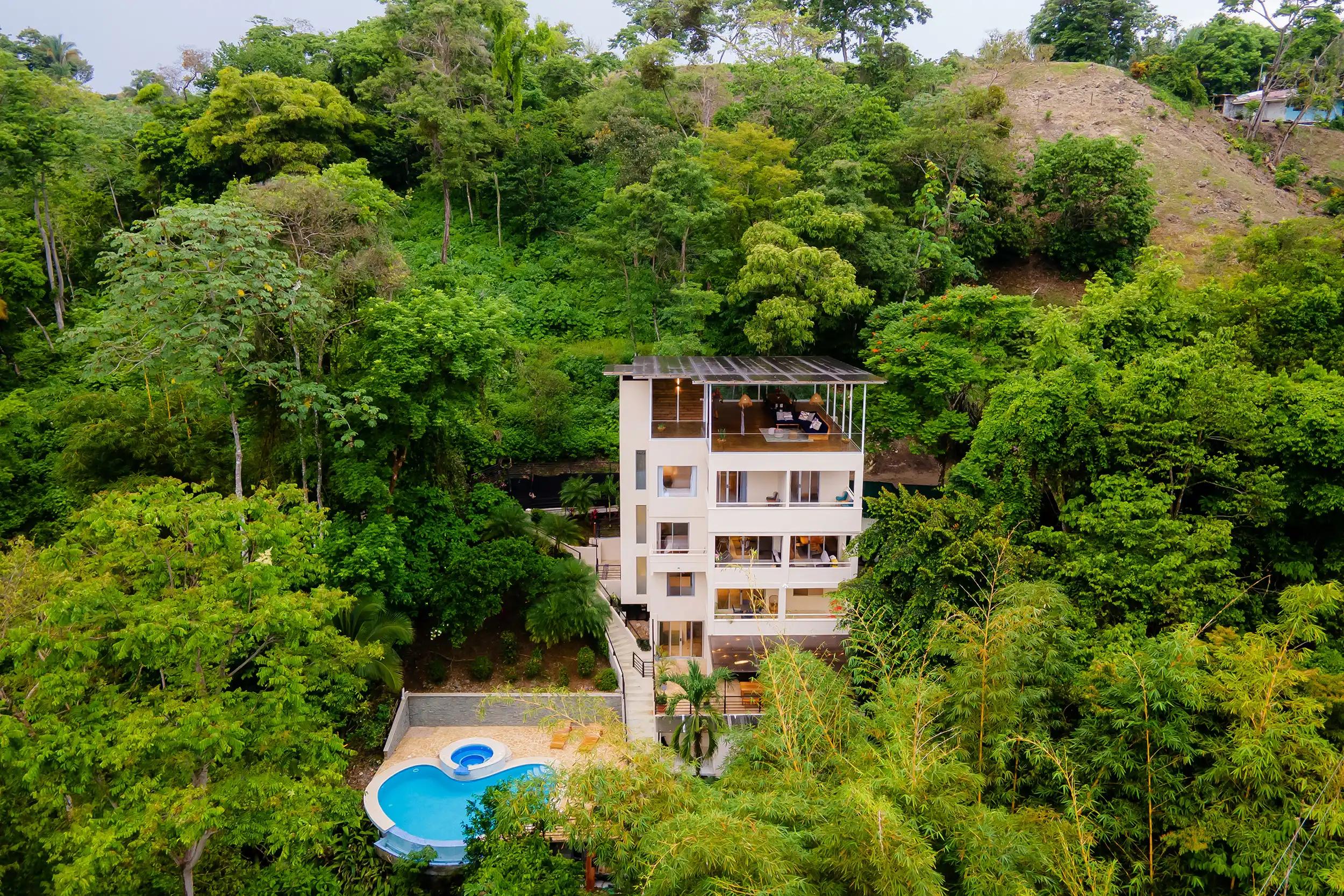 Four-story Villa Caimito rising from the rainforest hillside above its curved pool and jacuzzi