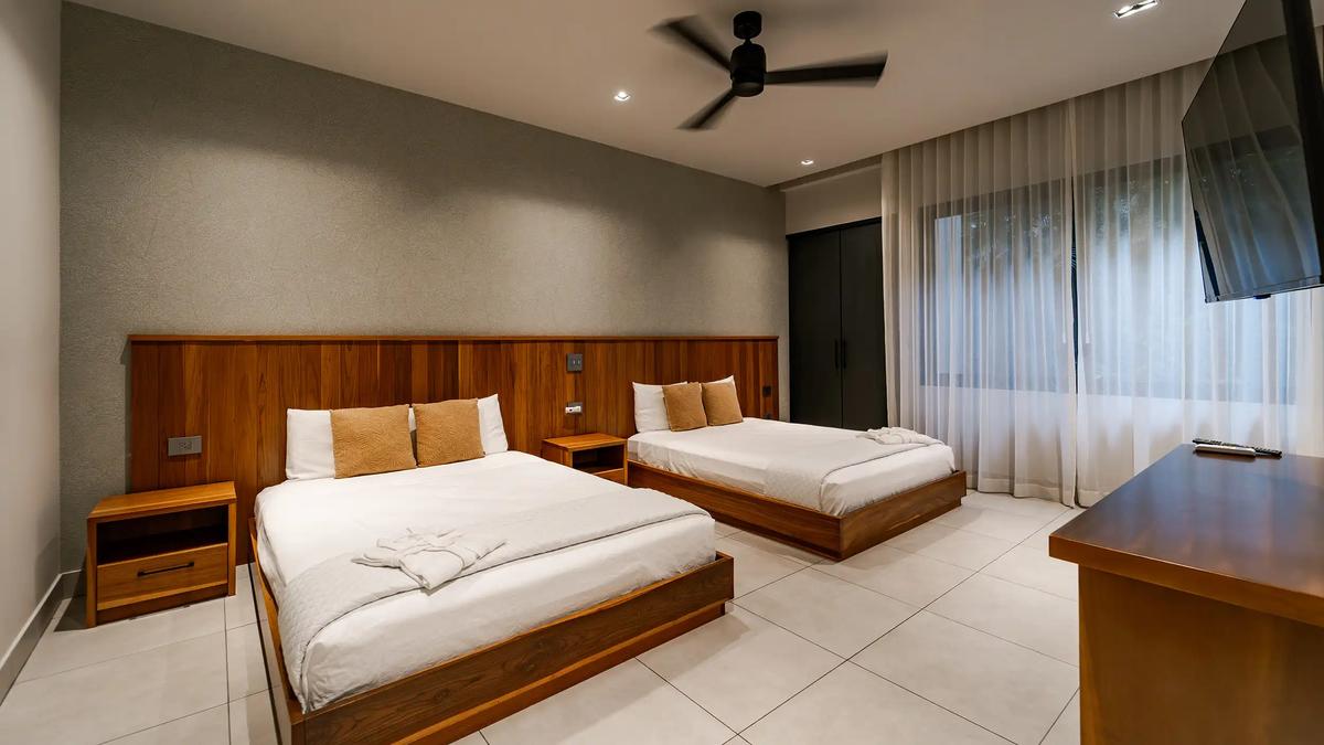 Casa Blue Marlin guest bedroom with two platform beds and wall-mounted TV