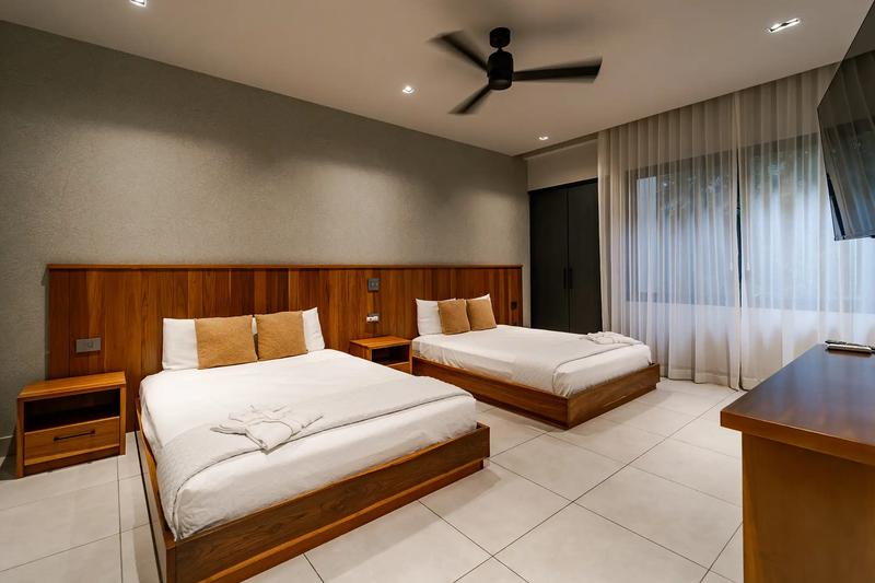 Casa Blue Marlin guest bedroom with two platform beds and wall-mounted TV