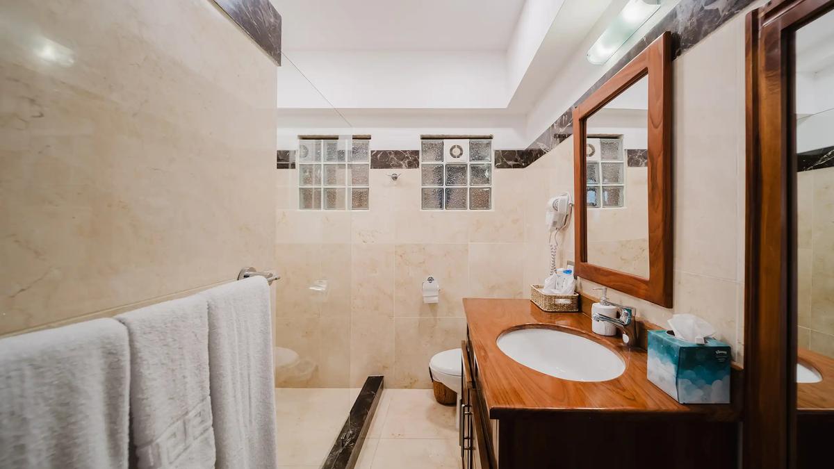 Casa Grande Vista bathroom with walk-in shower, white towels and wood vanity