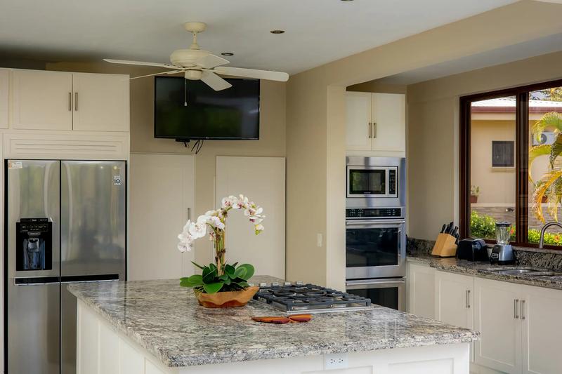 Casa Mariposa kitchen with granite island, gas cooktop, and stainless appliances