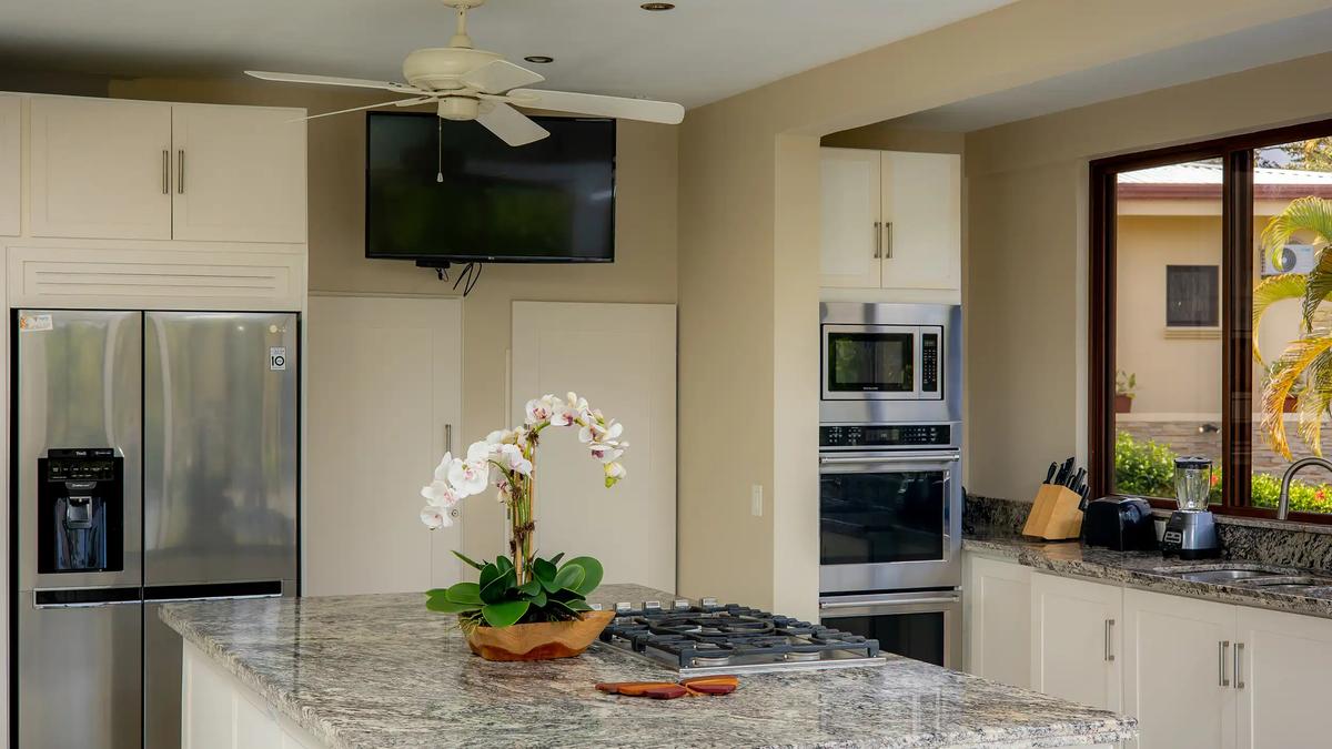 Casa Mariposa kitchen with granite island, gas cooktop, and stainless appliances