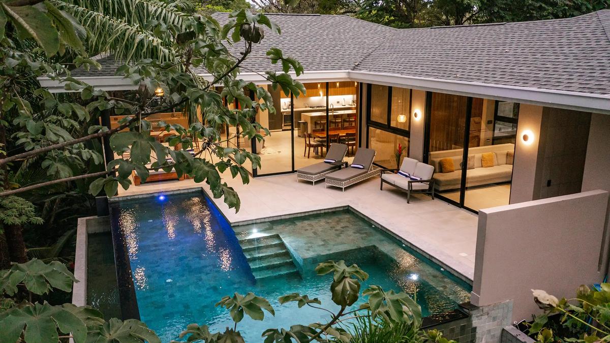 Evening aerial of Casa Blue Marlin with lit interiors opening to the pool terrace