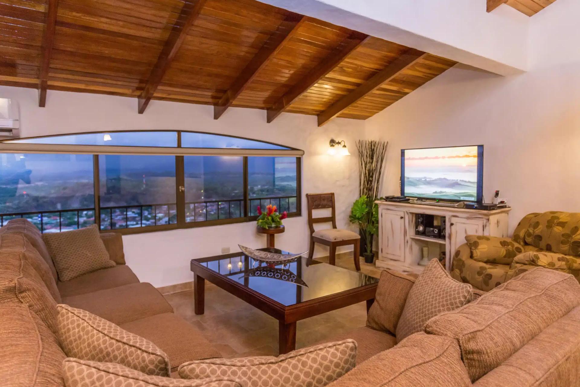 Evening living room at Casa Moreno with town lights beyond the arched window