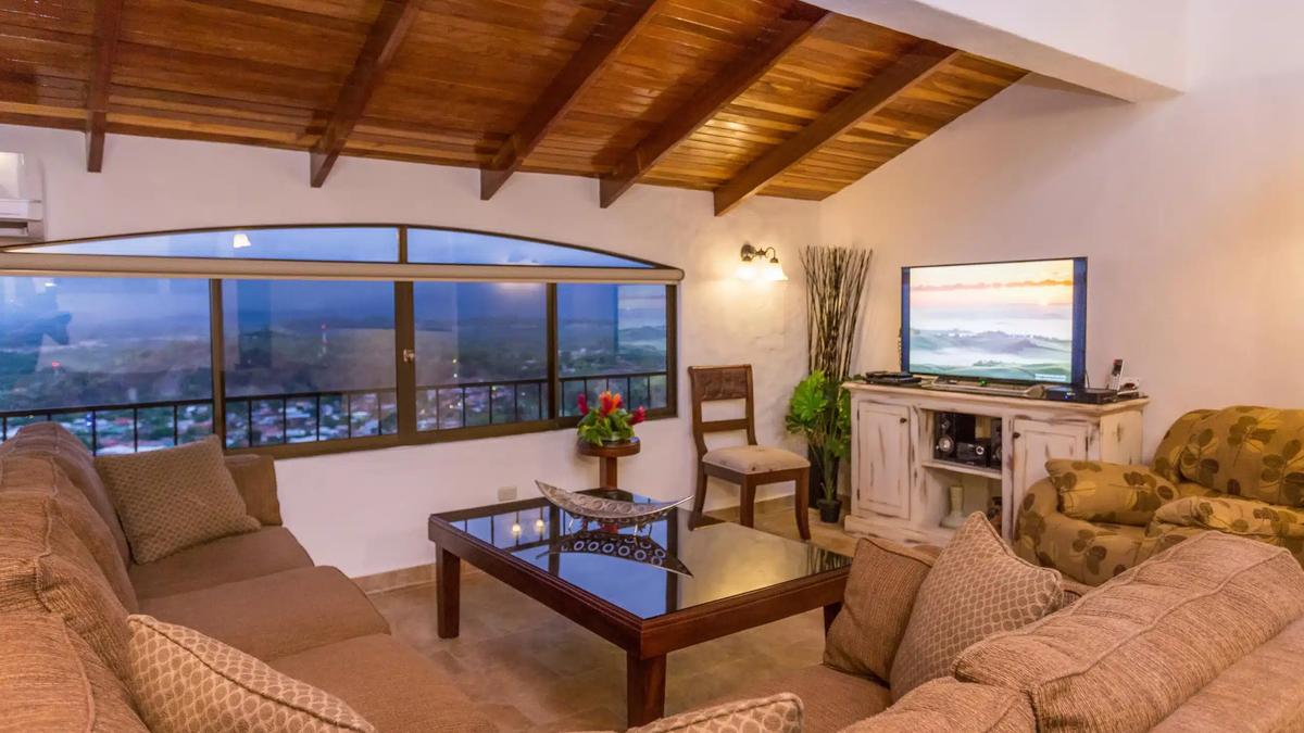 Evening living room at Casa Moreno with town lights beyond the arched window