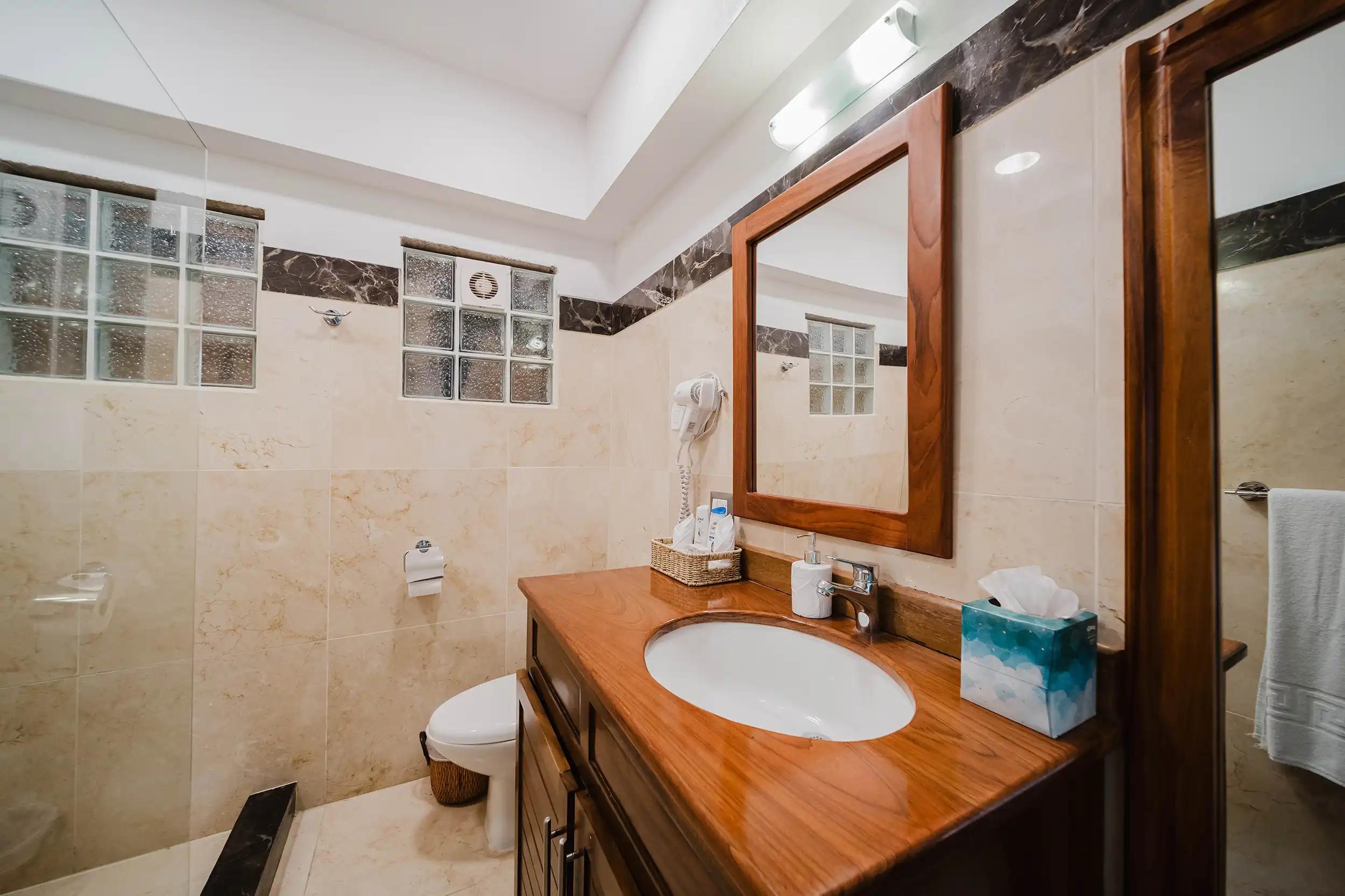 Bathroom at Casa Grande Vista with wood vanity and marble tile walls