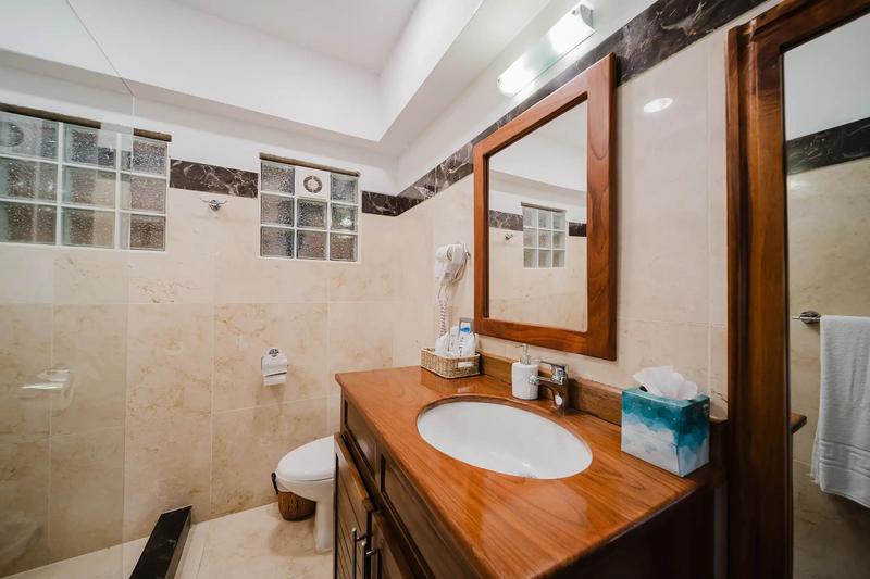 Bathroom at Casa Grande Vista with wood vanity and marble tile walls