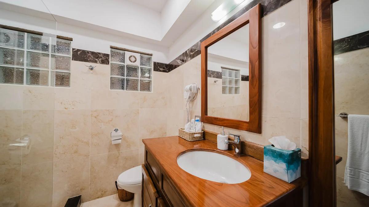 Bathroom at Casa Grande Vista with wood vanity and marble tile walls
