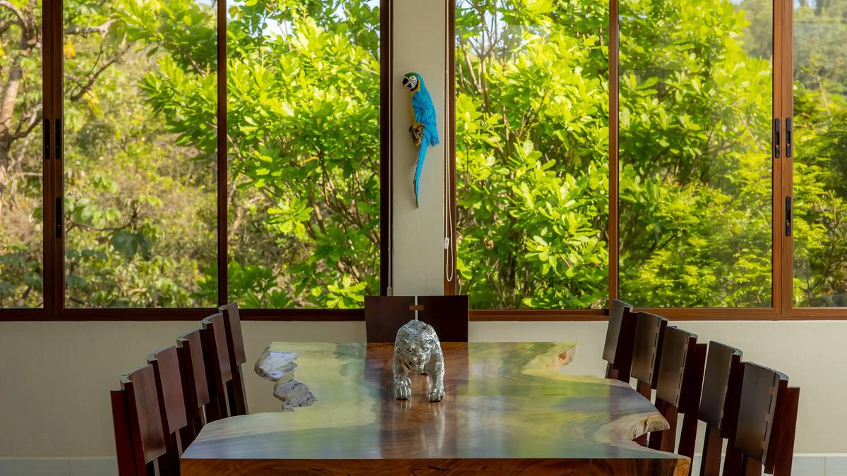 Live edge dining table at Casa Mariposa with jaguar sculpture and jungle views