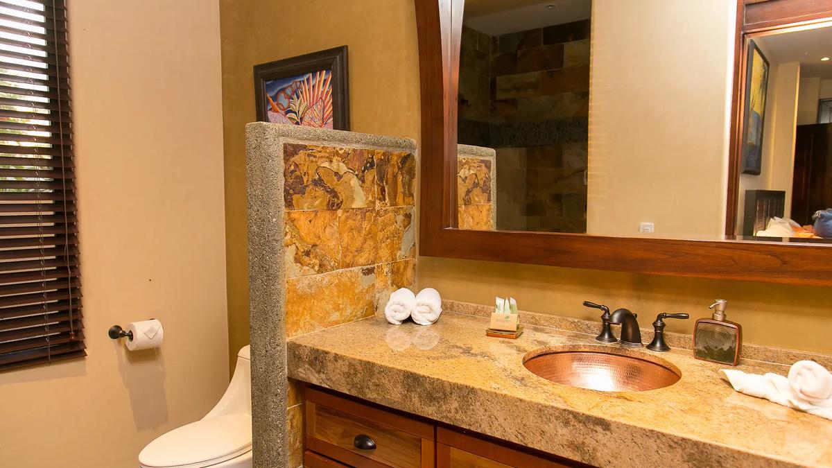 Bathroom vanity with hammered copper sink and granite countertop at Casa Anaka