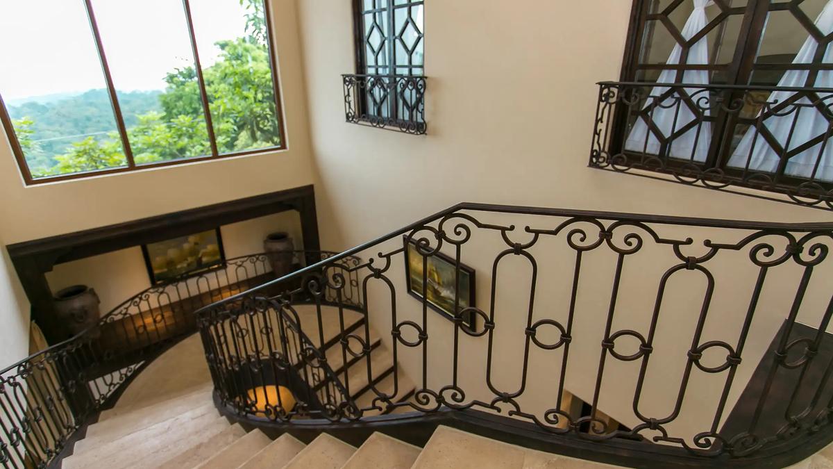 Curved staircase with wrought iron railing inside Villa Marbella