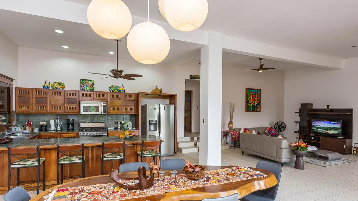 Kitchen at Casa Pura Paz with dining table in front and living room beyond