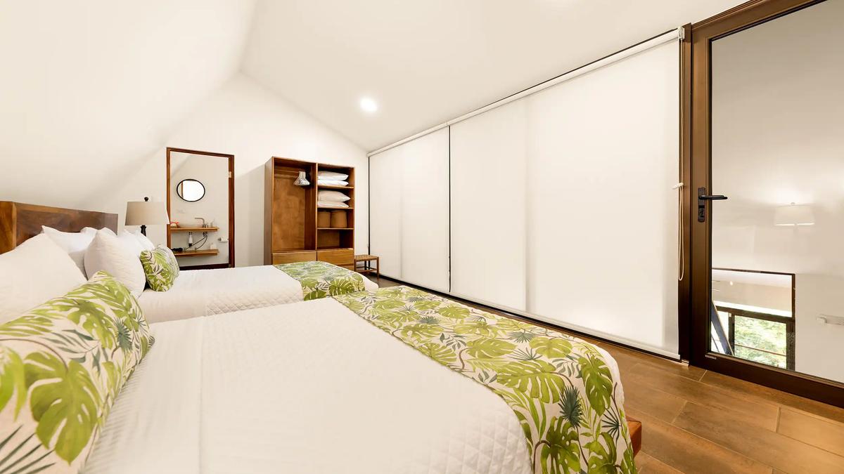 Loft bedroom at Casa Vista Verde with two beds and privacy shades lowered