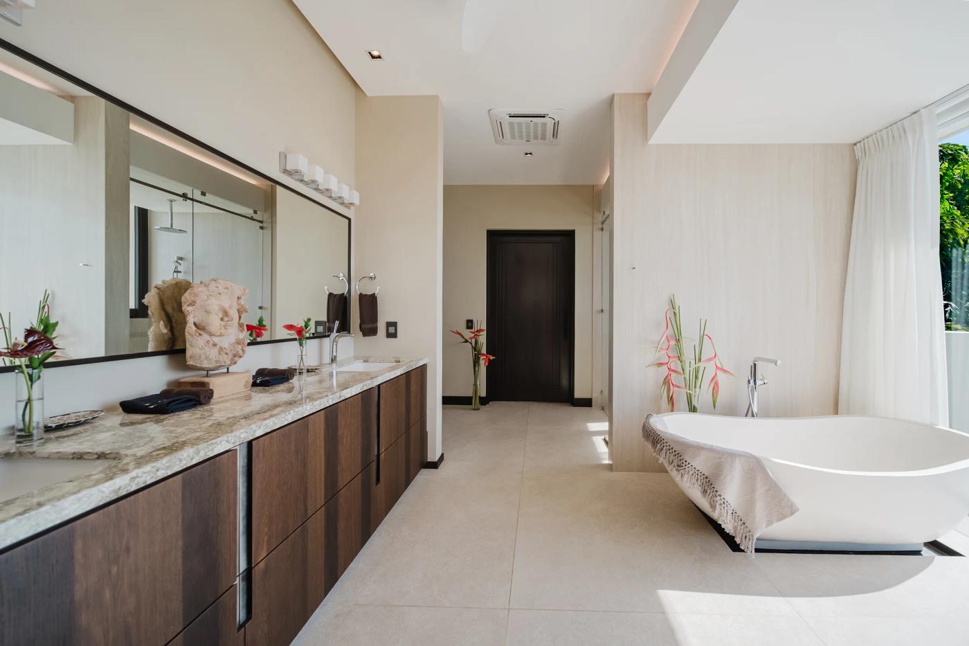 Double vanity and freestanding tub in a Casa Nola bathroom with garden light