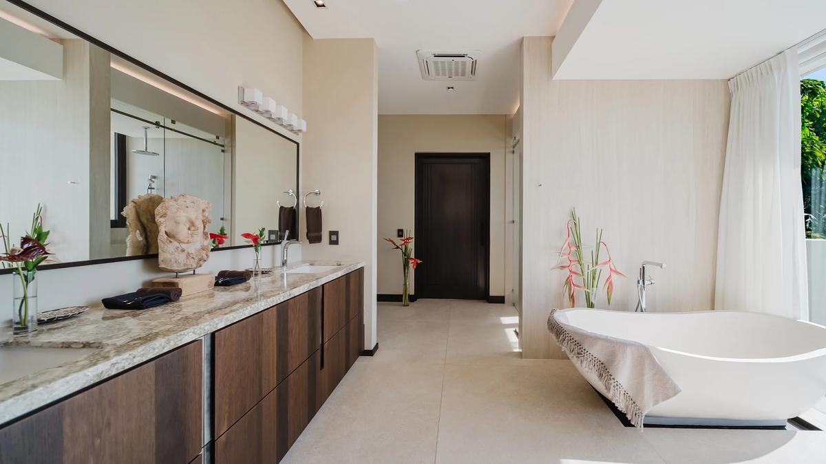 Double vanity and freestanding tub in a Casa Nola bathroom with garden light