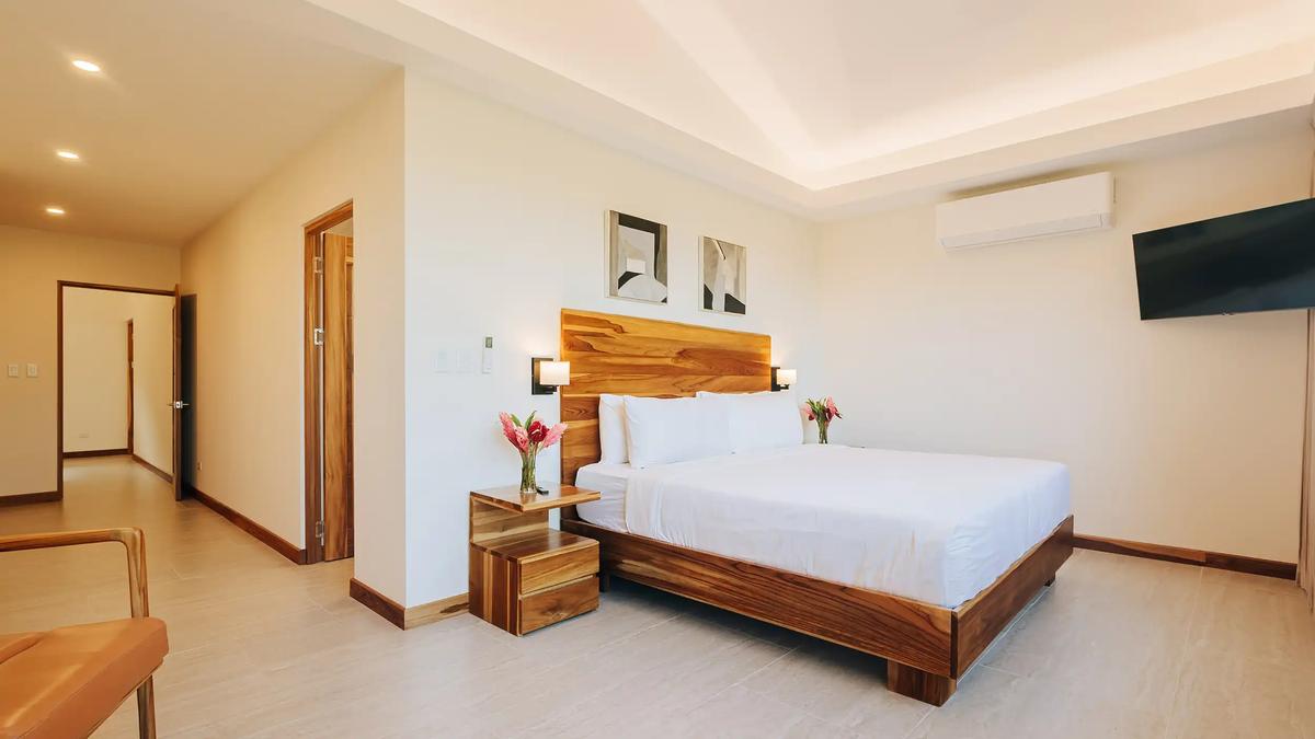 Spacious king suite at Casa Dos Cascadas with cove lighting and sitting area