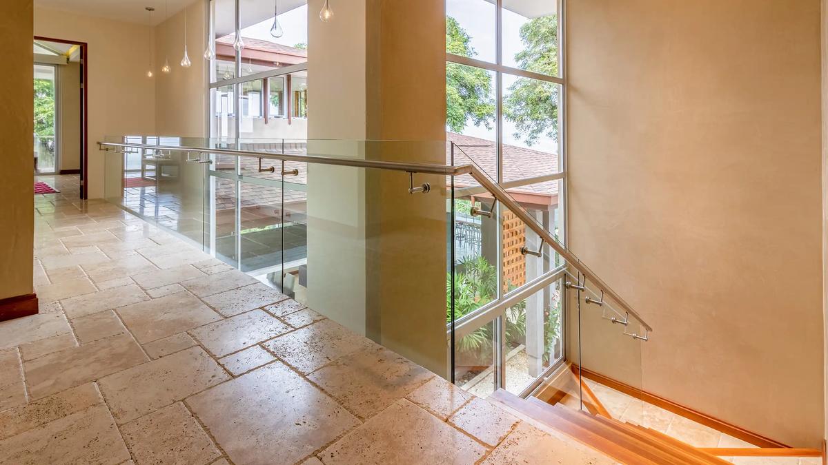 Upstairs hallway at Casa Contee with glass railings and teardrop pendant lights