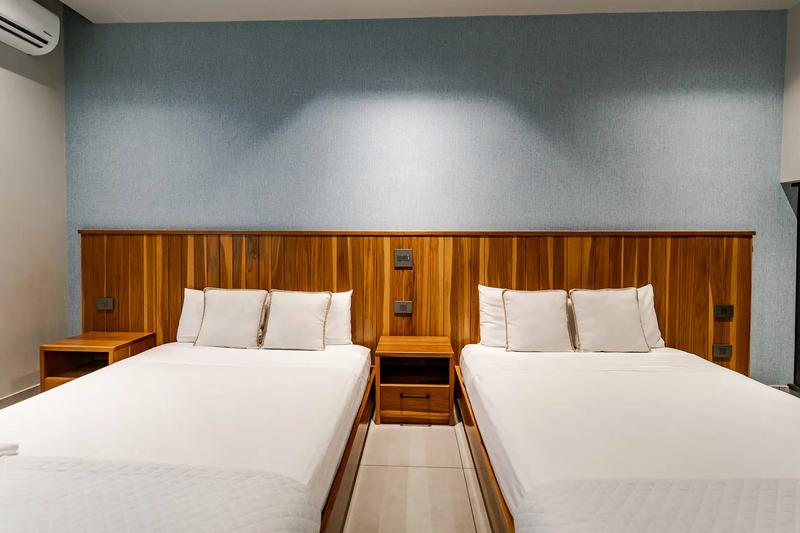 Two beds sharing a full teak headboard wall at Casa Blue Marlin