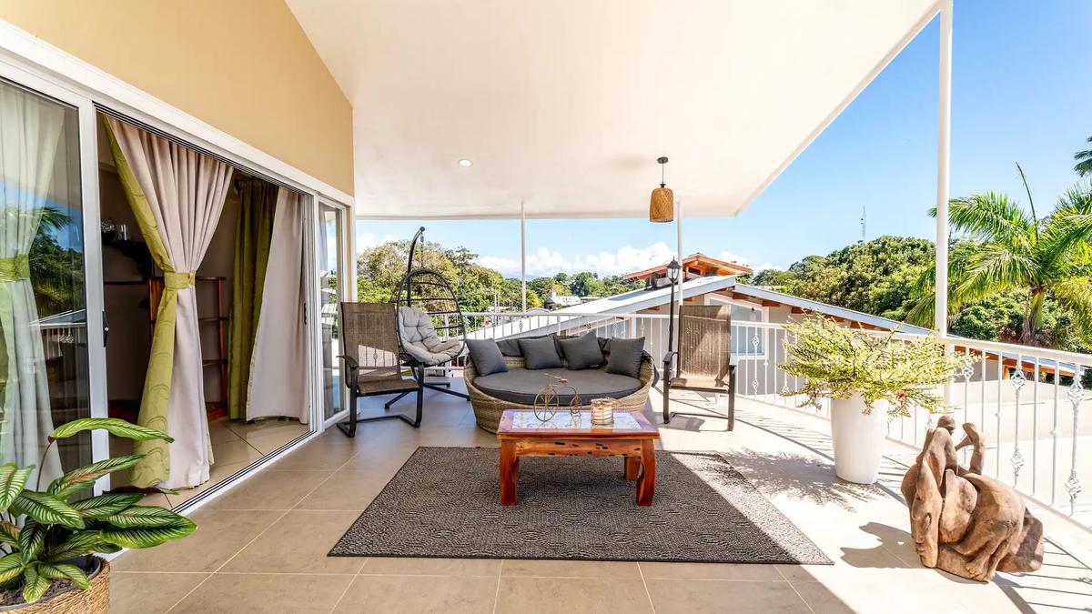 Covered terrace lounge with daybed and hanging egg chair at Casa Alta Vista