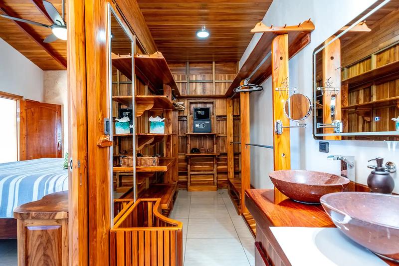 Teak walk-in closet with double stone sinks in the master suite at Casa Alta Vista