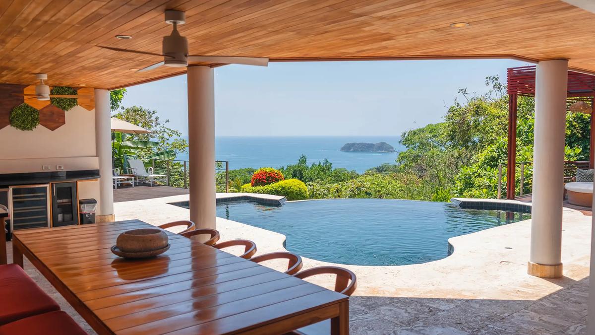 Poolside dining table at Casa Anjali facing the Pacific and an offshore island
