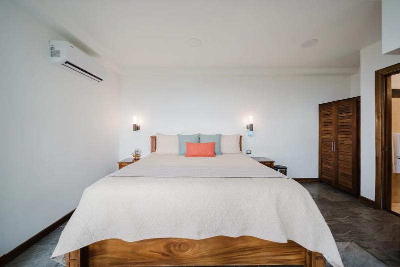 Bedroom at Casa Grande Vista with wall sconces and louvered teak closet doors