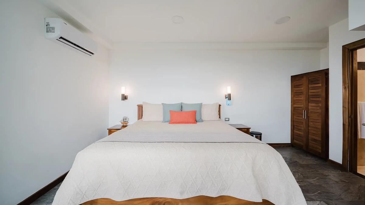 Bedroom at Casa Grande Vista with wall sconces and louvered teak closet doors
